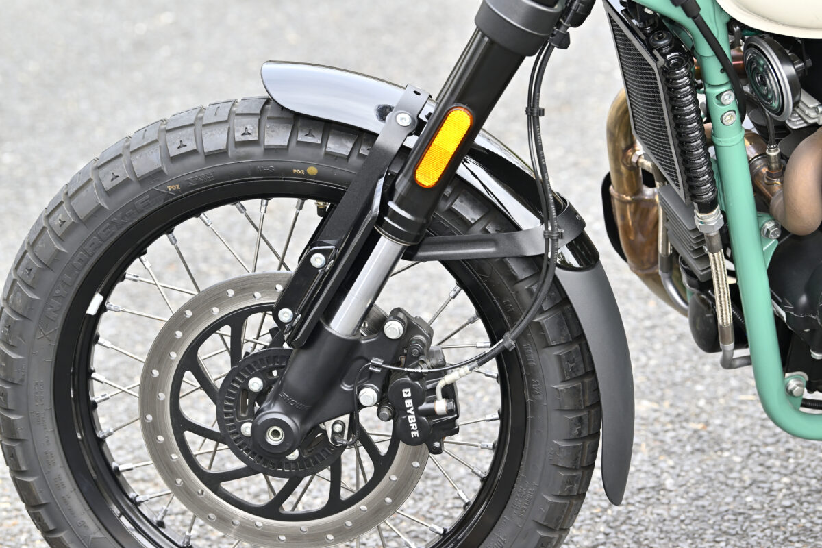 フロントフェンダーには長めなマッドガードを装備。タイヤはピレリのスコーピオンラリーSTRによく似たブロックパターンを持つMRF NYLOREX-F。チューブレス仕様のラジアルタイヤにチューブを入れて組んでいる。今回のダート試乗に当たっては前後1.2まで空気圧を落としている。