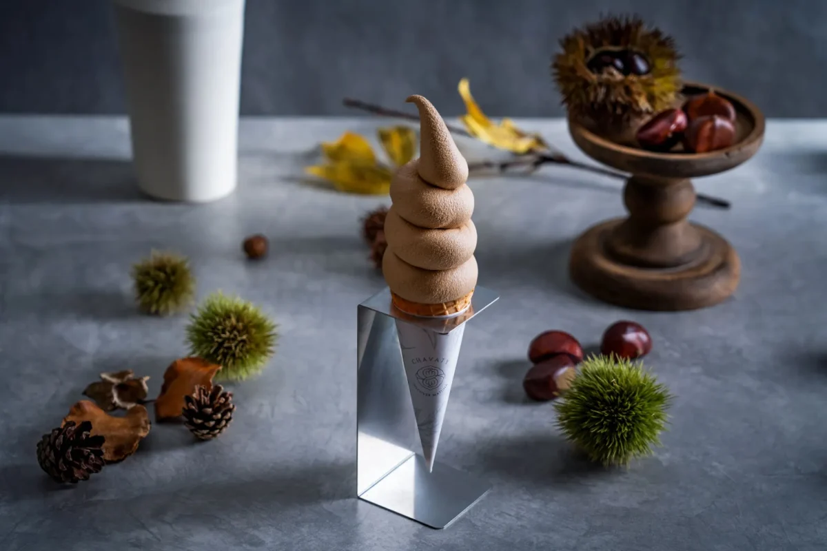 秋のデザートをイメージした写真。栗のソフトクリームが特徴的で、周りには栗や松ぼっくり、葉っぱが配置されている。