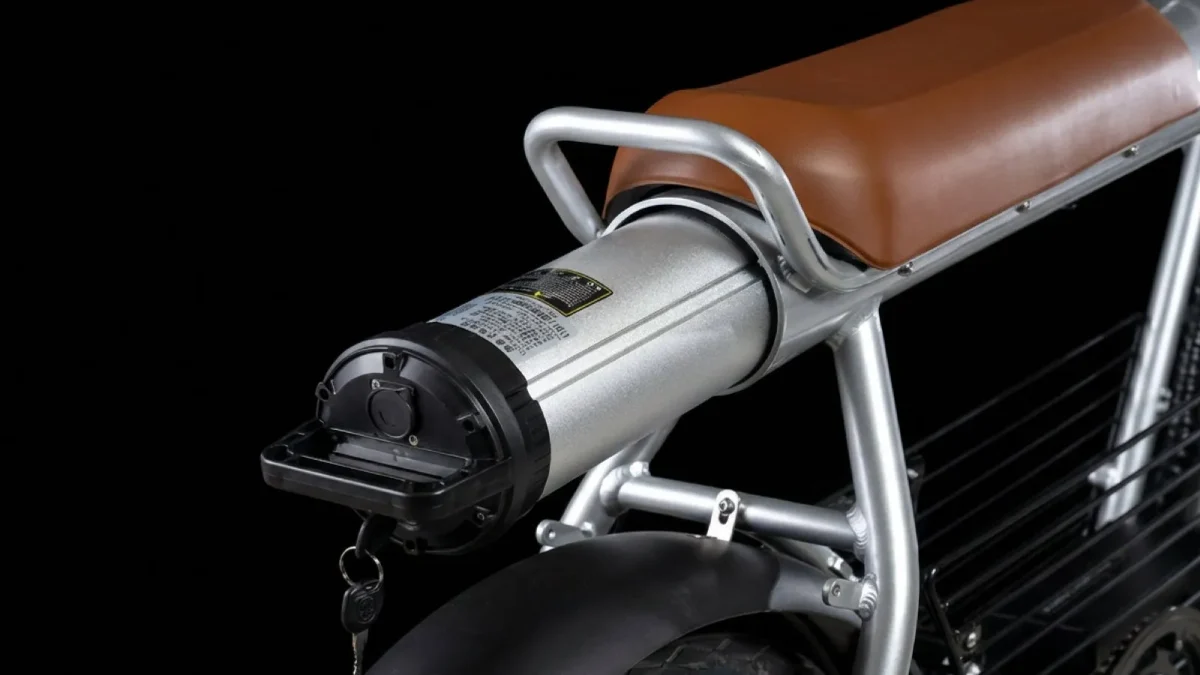 電動バイクのバッテリー部分のクローズアップ。銀色のバッテリーパックと黒いカバーが見える。