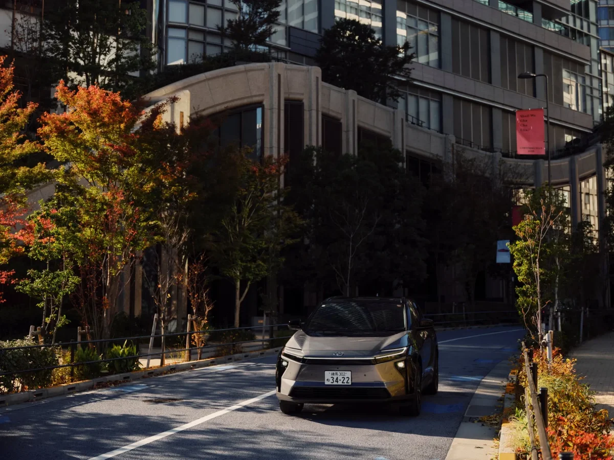 秋の都会の街路を走るTOYOTA bZ4X