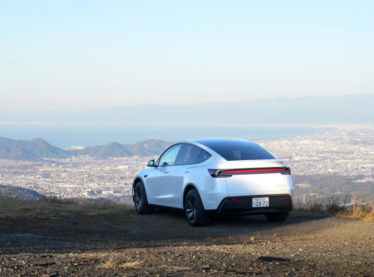 山の上から撮影された白いテスラ車