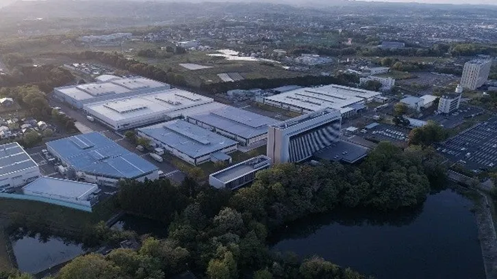 空撮された工業団地の写真。多くの建物があり、周囲には緑地と水辺が見える。
