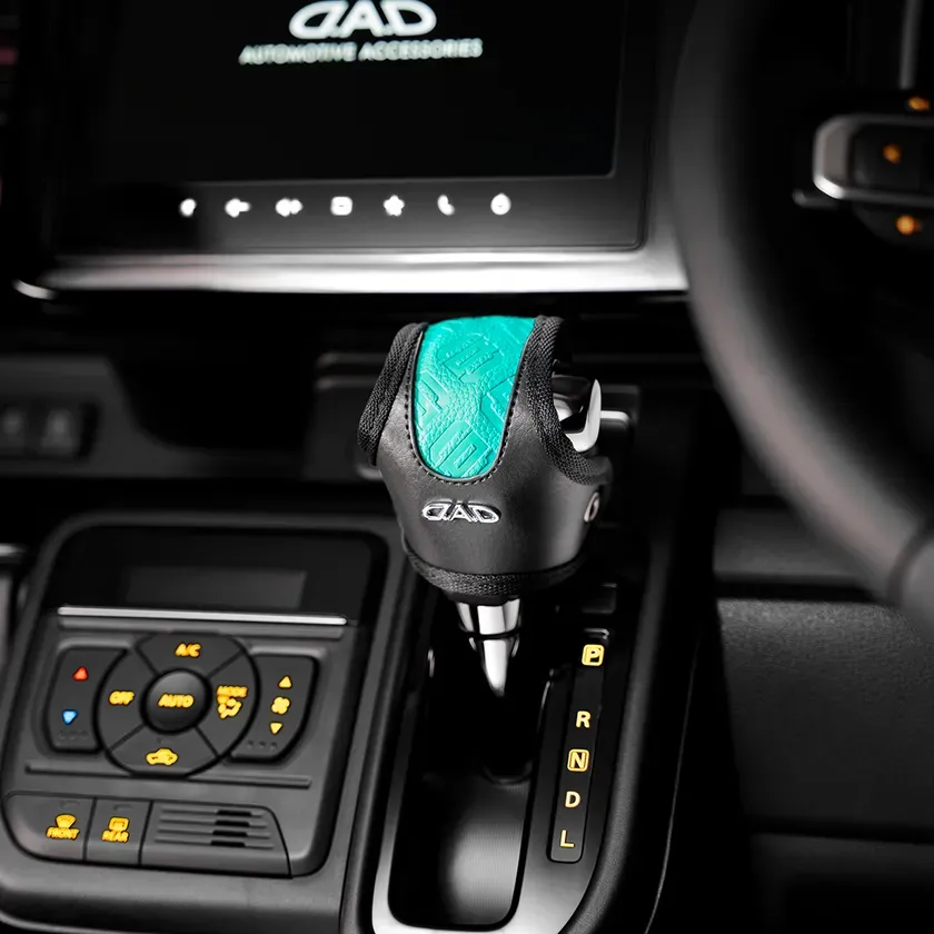 車のシフトノブに装着された、ターコイズブルーのアクセントが特徴的なGADブランドのシフトノブカバー。
