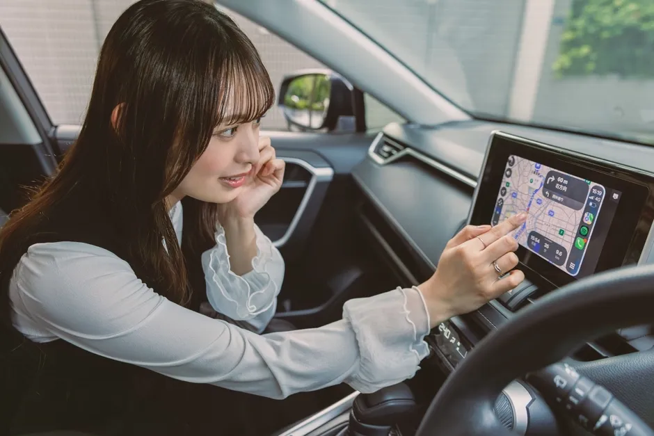 車内でナビ画面を操作する女性