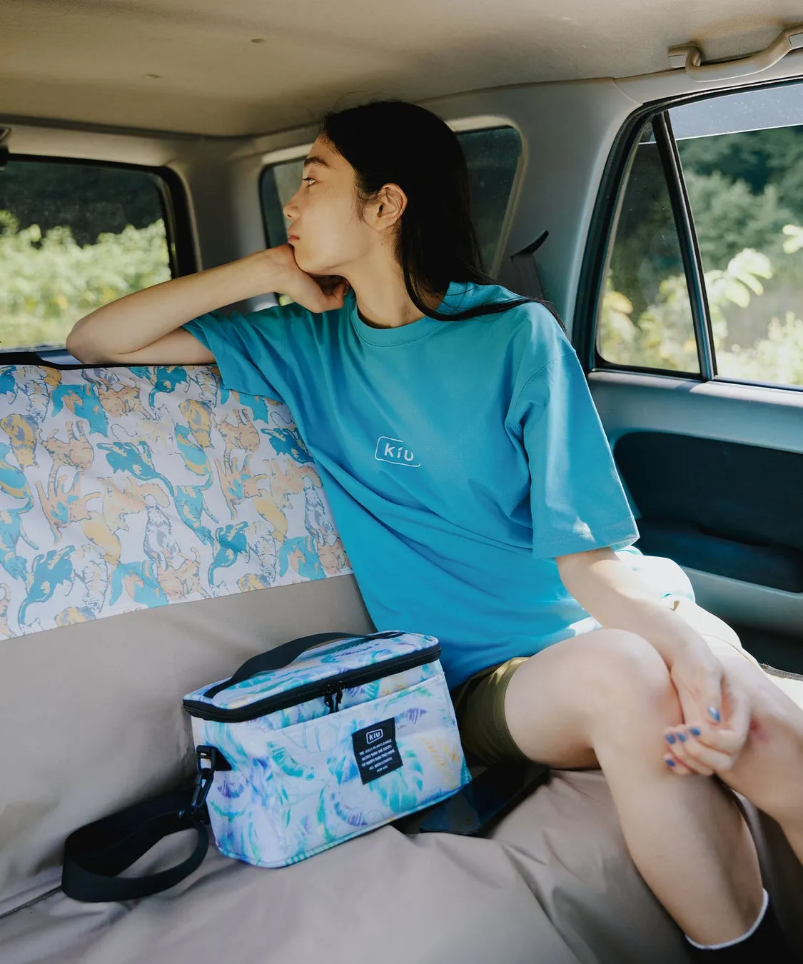 車内でくつろぐ女性とKiUのシートカバー