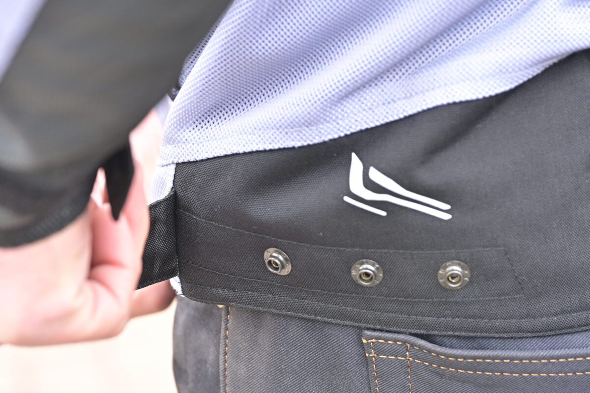 裾には３段階のアジャスターを装備。ボタン上部にはリフレクターもレイアウト。